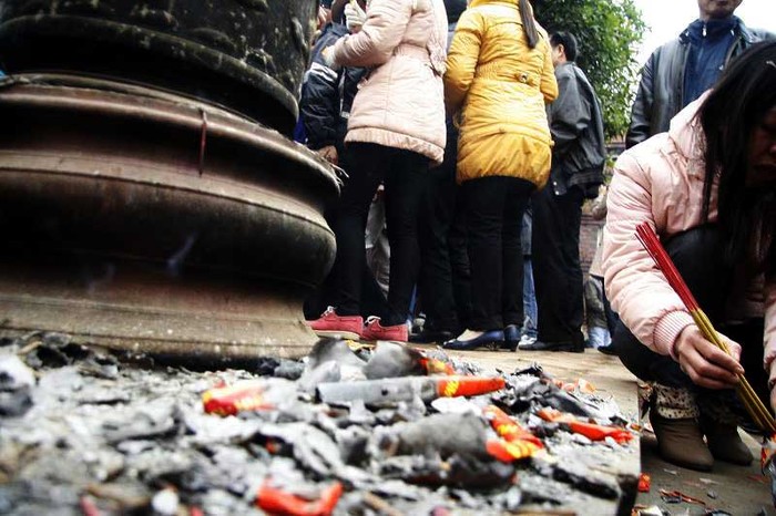 Không đủ kiên trì chờ xếp hàng đươc đốt tại lò, nhiều người "ngả" luôn vàng mã ra đốt trên bậc thềm của nhà chùa
